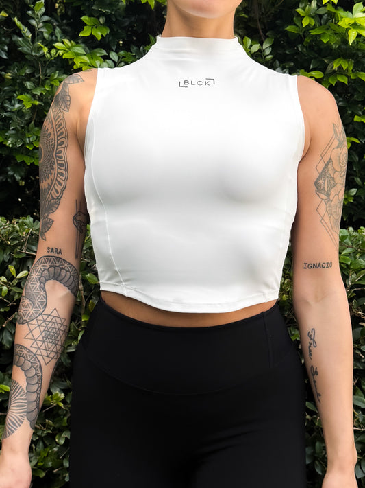 Person wearing a white sleeveless top with 'Lululemon' branding against a green leafy background.